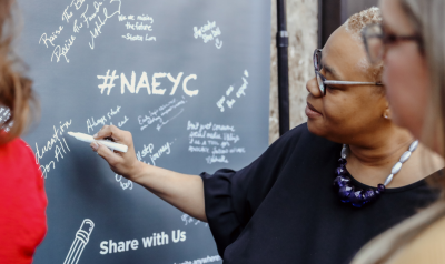 Woman responding to a prompt on a chalkboard