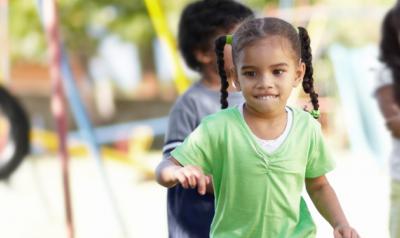 Little girl playing with a green shit on