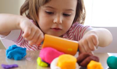 young girl rolling playdough