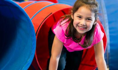 Young girl climbing out of a slide.