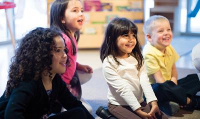 Four preschool students sitting on floor