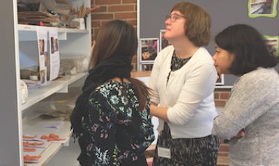 Three teachers looking at student artwork