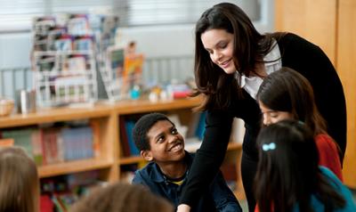 A teacher with students in a classroom.