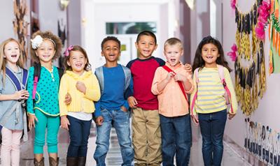 A diverse group of young children with backpacks.