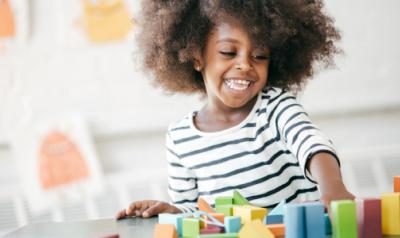 A happy child playing with blocks.