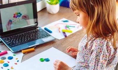  Una niña haciendo arte frente a una computadora.