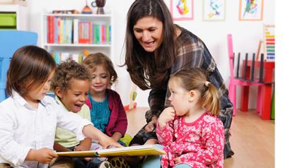 A teacher showing a picture book to children.