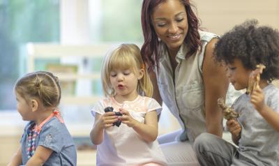 a teacher playing with children in a classroom