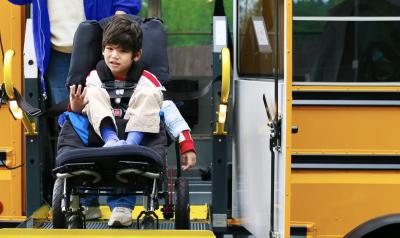 a child in a wheelchair exiting a bus