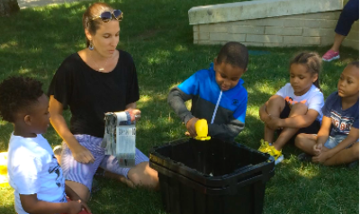 Children and an adult engage in a gardening project.