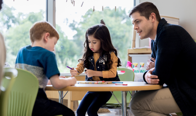 A teacher with students in a classroom.