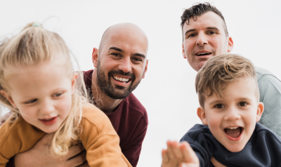 Two fathers play with their kids.