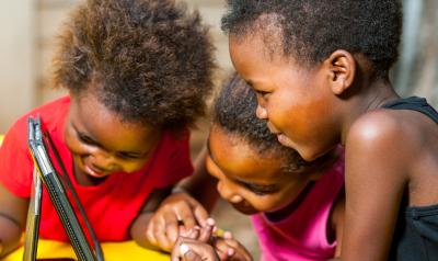 A group of children looking at an iPad together.