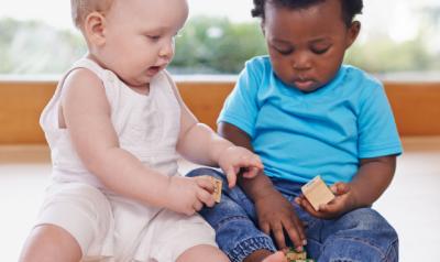 two toddlers playing with blocks together