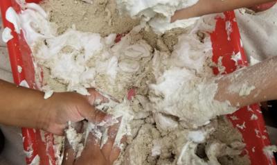 Children playing with sand and shaving cream at school