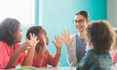 Teacher and students with hands up