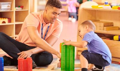 a teacher playing with blocks with a child