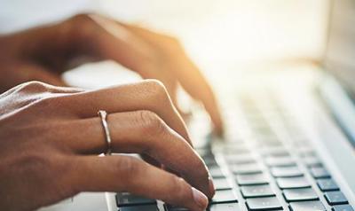 Hands typing on a computer