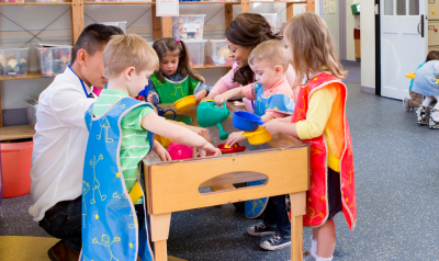 a group of children playing with a water table