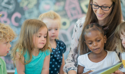 children reading with a teacher