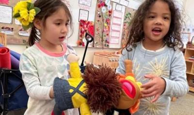 two children playing with a puppet