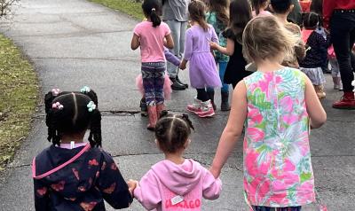 Children holding hands while walking outside
