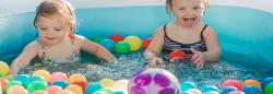 Toddlers playing with toy balls in pool