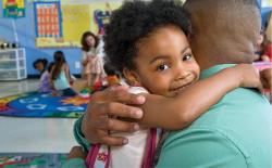 Girl hugging father in classroom