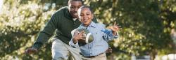 Father and son running and playing with a football outdoors