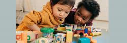 Two toddlers playing with blocks