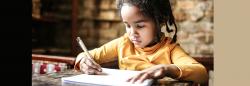 Young girl writing at a desk at home