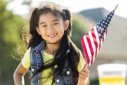 Preschool aged girl holding an american flag