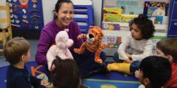 Teacher plays with puppets during group time with toddlers