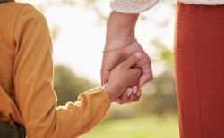 child and adult holding hands