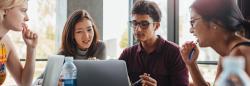 Adult students looking at a computer screen together