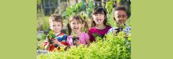 Group of diverse children holding plants outside