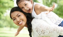 Young girl on her mother's back outside