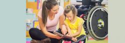 Teacher and student with a disability reading a book together