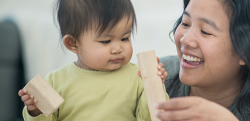 Mother playing with blocks with her young child.