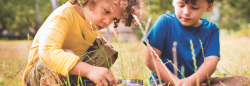 Two kids looking through magnifying glass