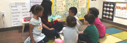 Teacher reading book to diverse students