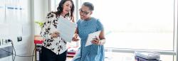 Two teachers reading a document