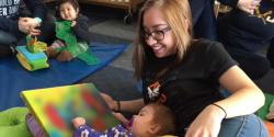 a teacher looking  at artwork with a child