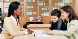 a teacher speaking with a parent and child