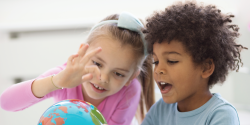 children studying a globe