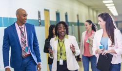 A group of educators walking down a school hallway