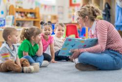 An early childhood educator reading to young children