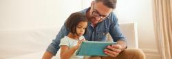 Father and daughter holding a digital tablet