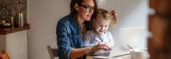 Mother and daughter typing on a laptop