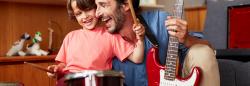 Father and son playing drums and guitar